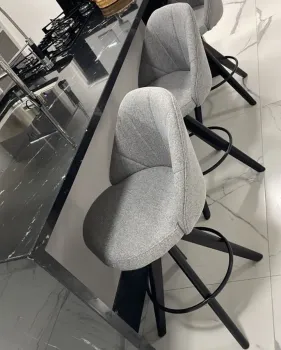 Banqueta Baixa Giratória 55 cm do chão ao assento, Modelo Viena Material Facto Cinza, Frente com costuras Pétala, Costas Lisa, Argola cor Preta, Pés cor Preto, para bancadas de 80 cm a 85 cm
