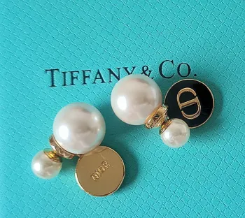 Brincos Dior placa redonda e pérolas. 