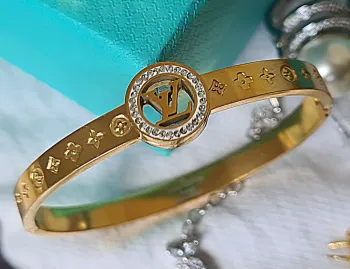 Bracelete Louis Vuitton dourado, símbolo redondo. 